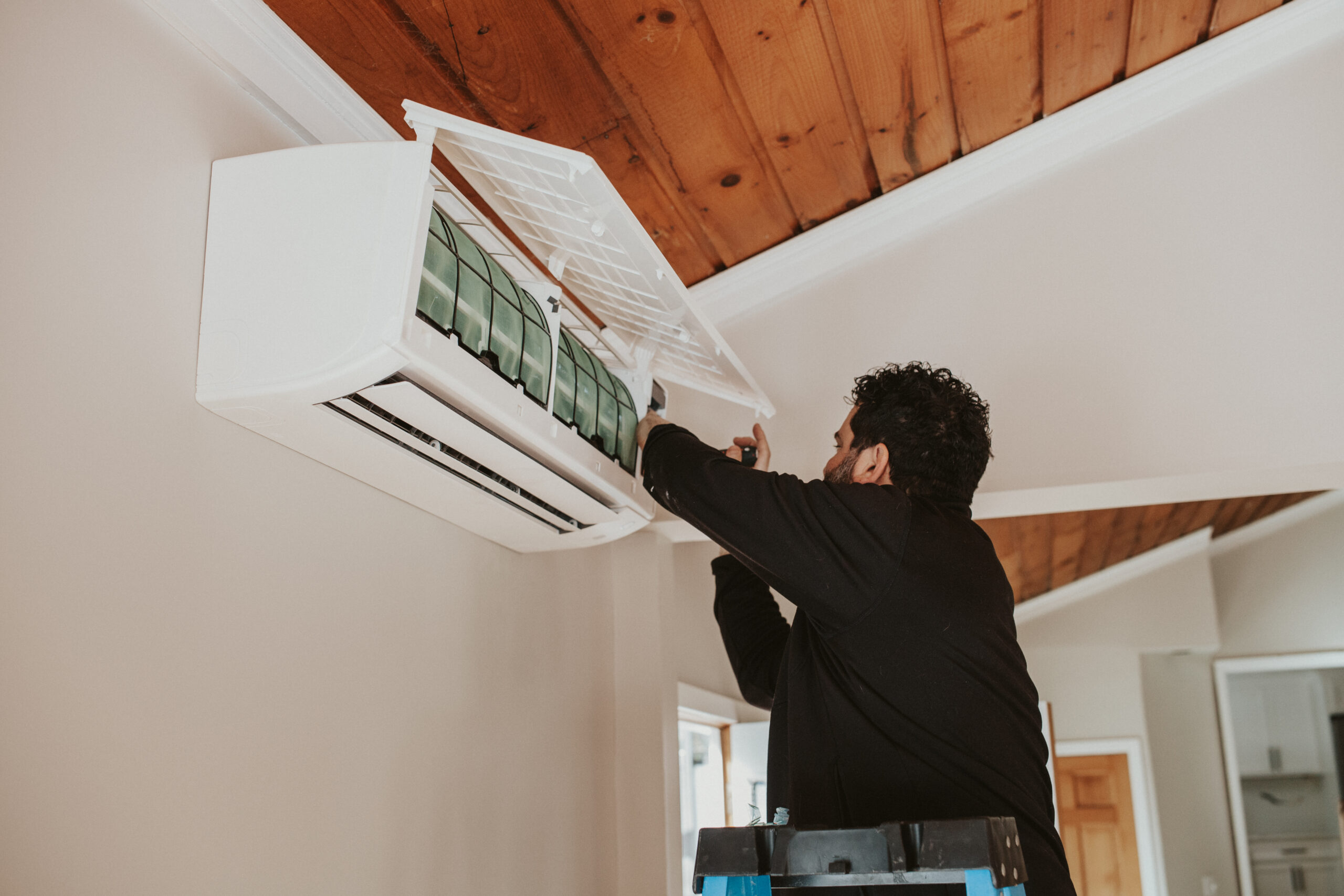 IMG_2029 HVAC technician replacing the air filter on a ductless mini split unit during a routine maintenance visit, ensuring optimal system performance and clean indoor air.